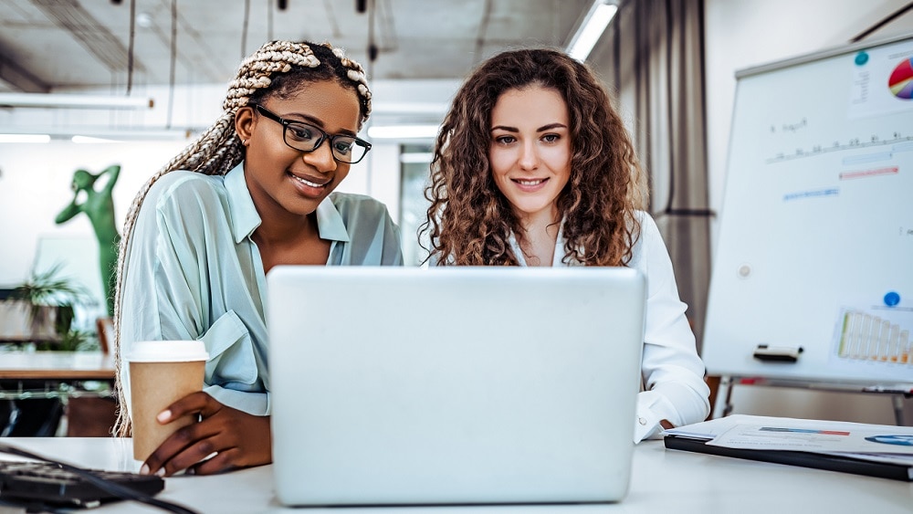 Two collegues collaborating at a laptop