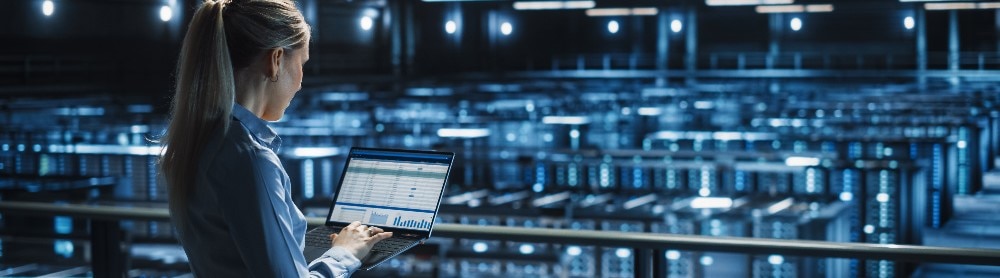 Female consultant working with laptop in a datacenter Female consultant working with laptop in a datacenter