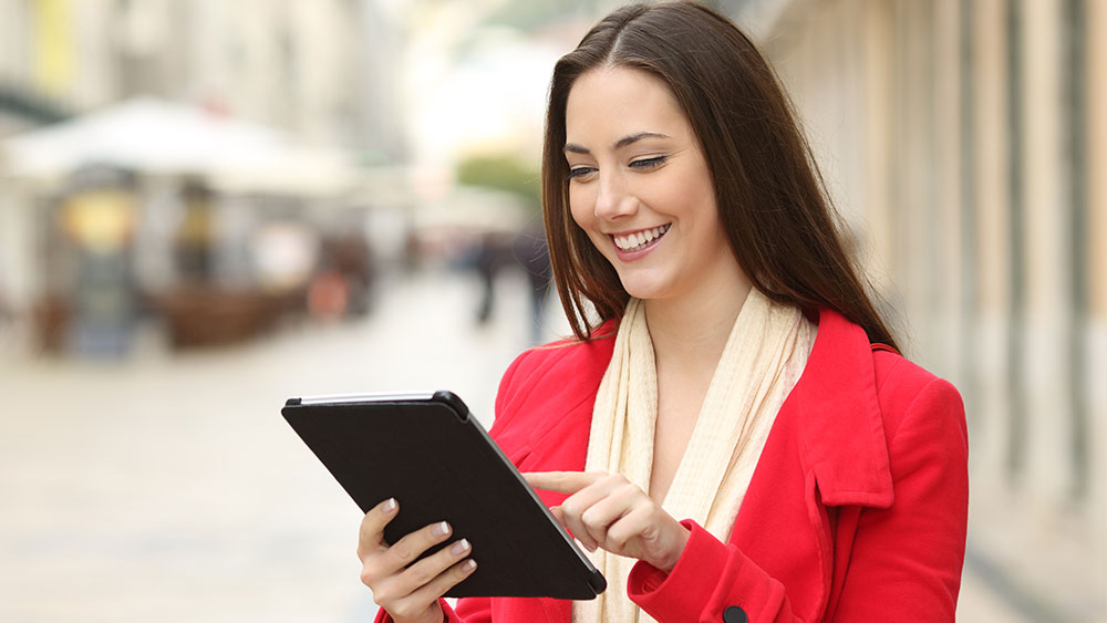 Smiling female consultant looking at a tablet outside