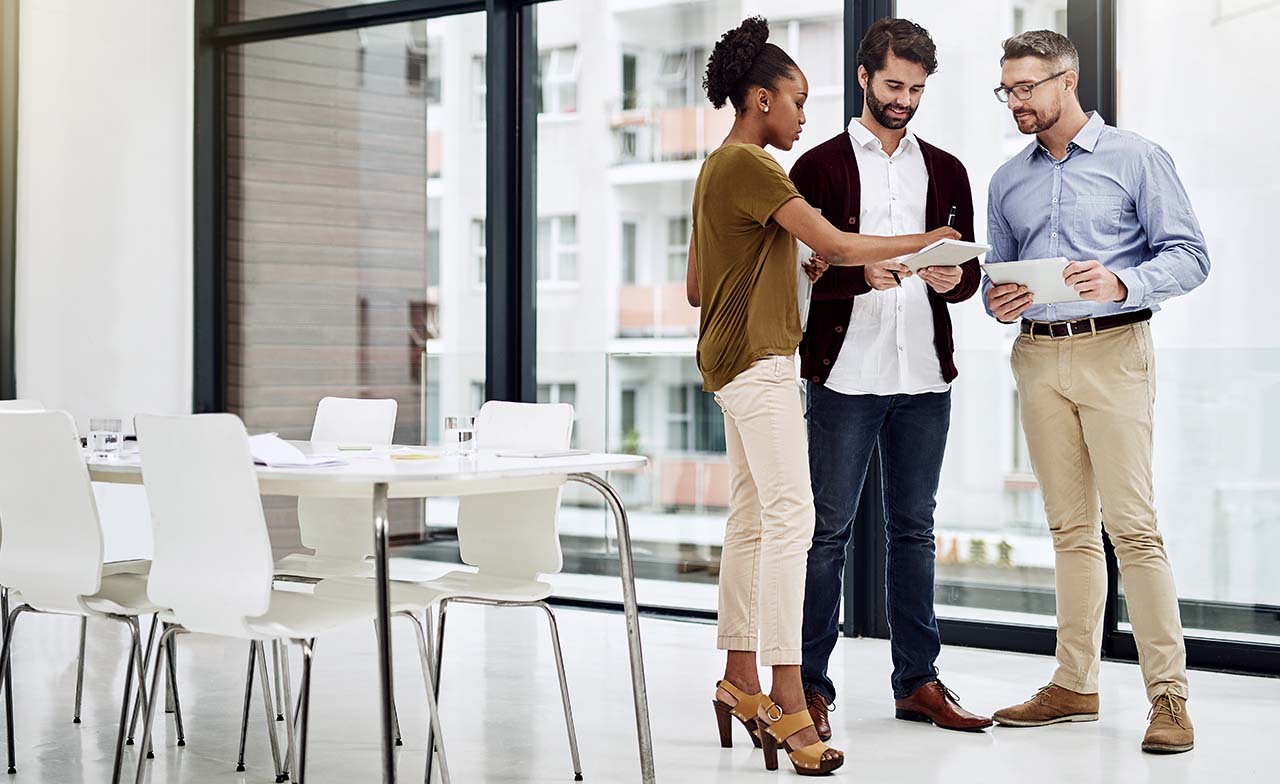 three advisory consultants discussing business while standing