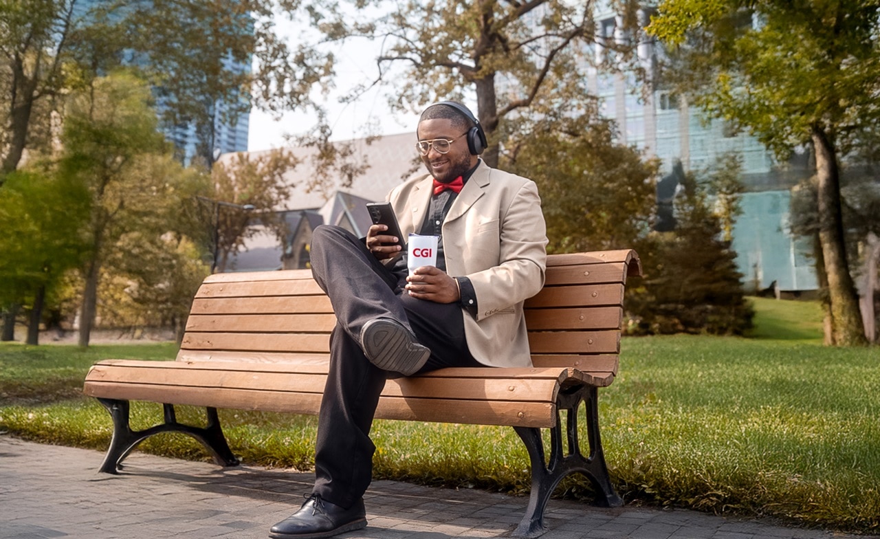 Man sitting on a bench reading outdoors