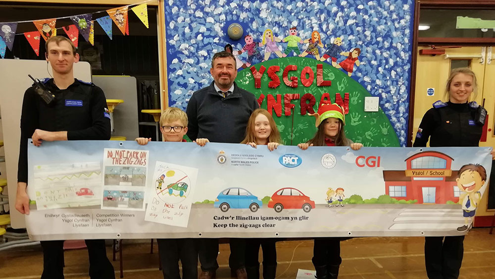 A powerful partnership - supporting the community with North Wales Police Children and police officers holding a banner