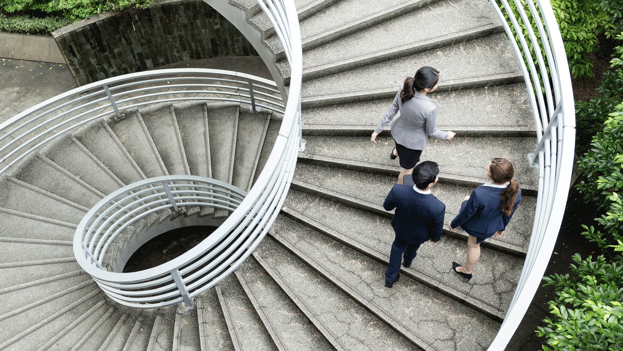 Managed IT services consultants on a large modern spiral staircase Managed IT services consultants on a large modern spiral staircase