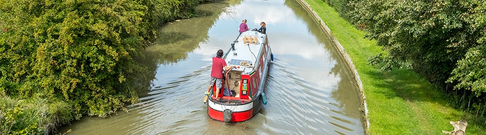 Canal baot Canal boat sailing on a canal surrounded by trees