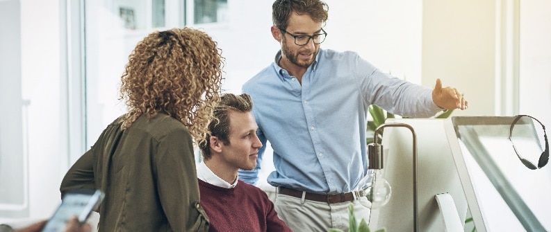 Professionals meeting in front of computer monitor