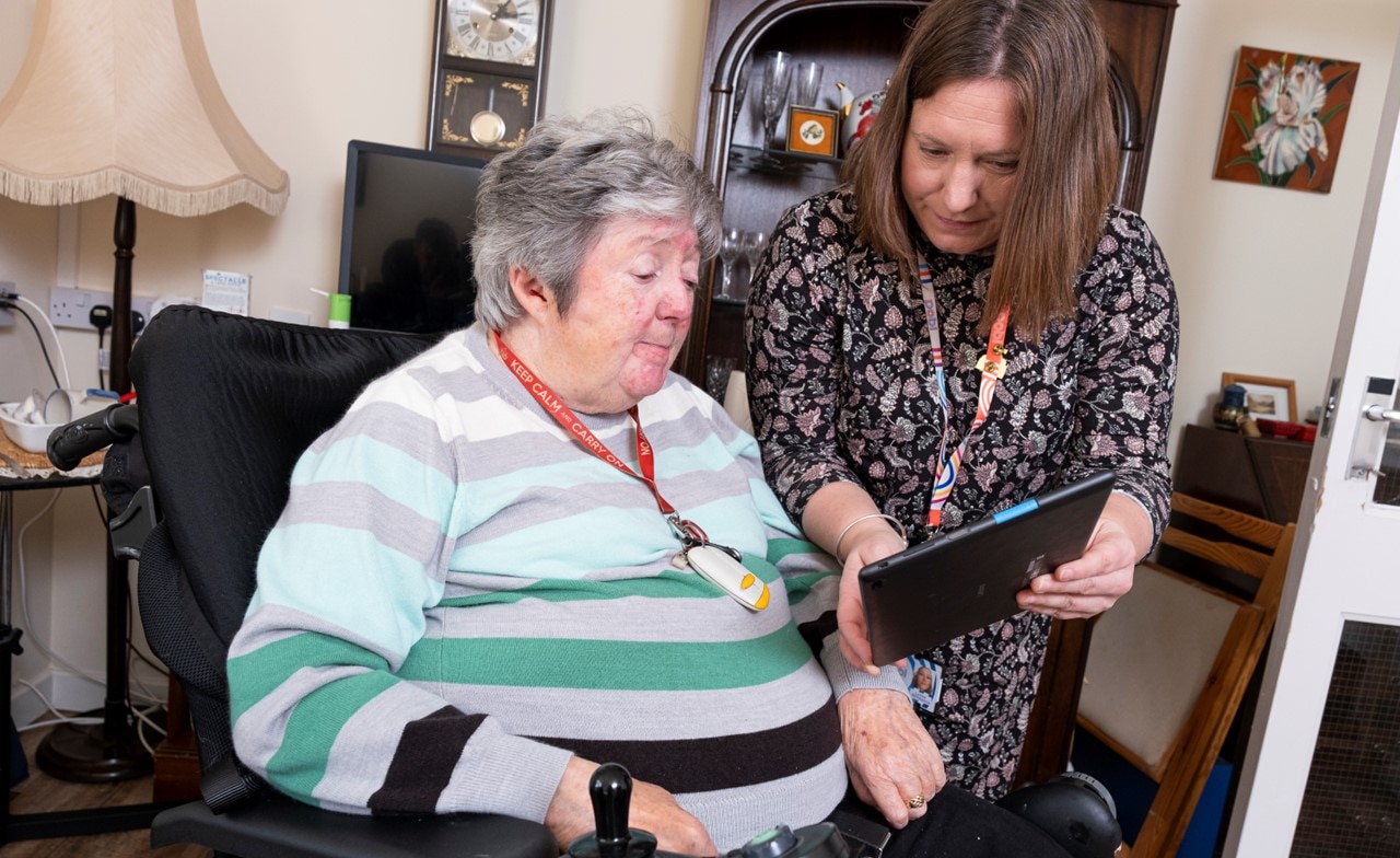 Social care worker showing patient something on tablet device Social care worker showing patient something on tablet device