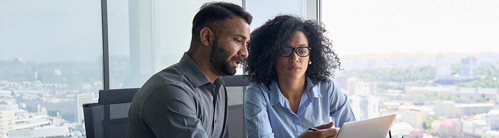 two consultants discussing information on a laptop