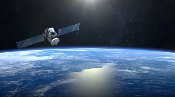 Kuvassa näkymä avaruudesta, etualalla satelliitti