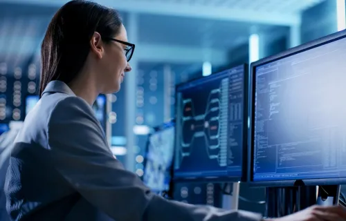 data scientist works on two computer monitors analyzing data