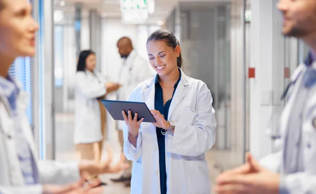 doctor using tablet in hospital hallway