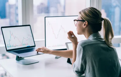 Executive working on multiple computer screens