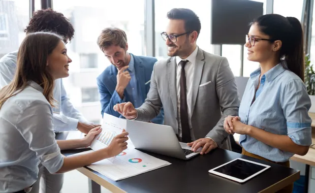 4 consultants at a table discussing AI-powered insights