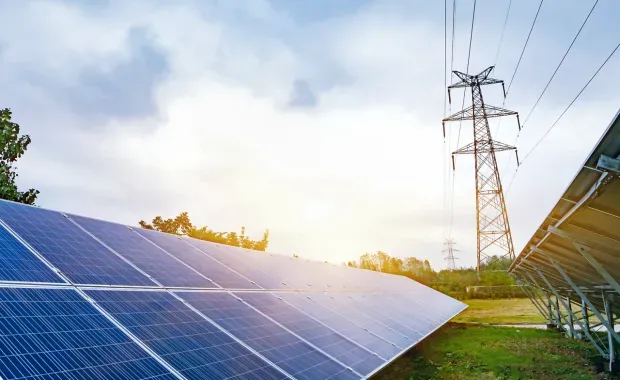 solar panels near electricity tower
