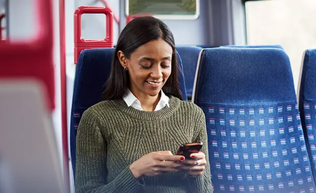 A woman using her mobile phone while seated inside the train
