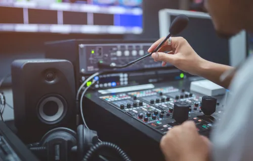 Professional in front of broadcast control panel