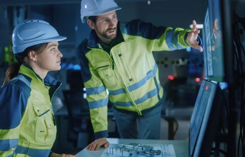 Project engineer talks to operator who controls facility production line