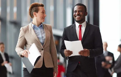 Two colleagues smiling while walking