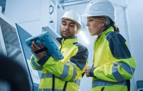 Two utilities workers looking at a digital tablet