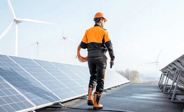a worker inspects rooftop solar panels